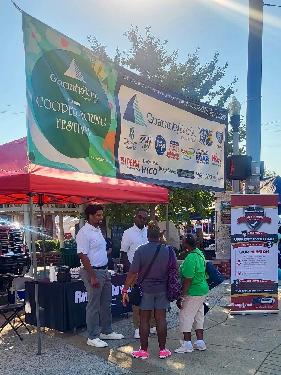 Rivard-Royall GMC team talking with festivalgoers at their booth under the Cooper-Young Festival banner in Memphis