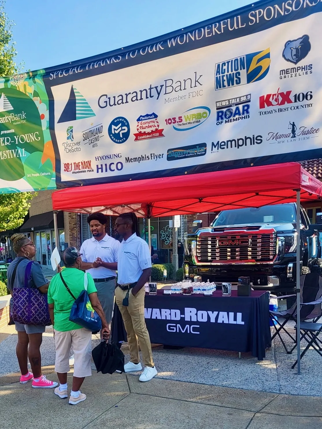 Rivard-Royall GMC booth at the 2026 Cooper-Young Festival with a lifted GMC Sierra 2500HD Denali on display behind the table