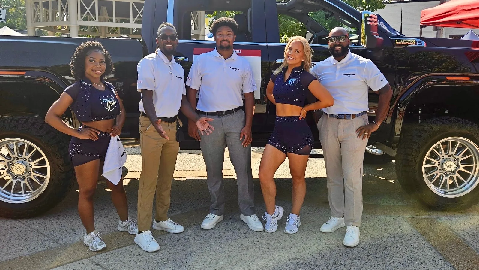 Rivard-Royall GMC team with two Memphis Grizzlies Grizz Girls in front of the lifted Sierra at the Cooper-Young Festival